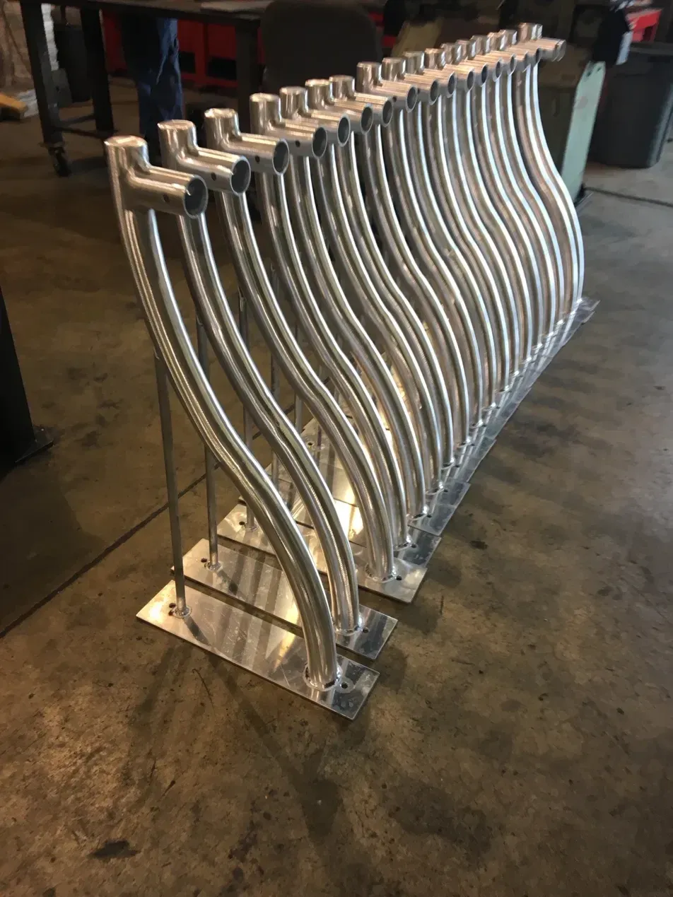 Row of curved, TIG welded aluminum light mounts on base plates