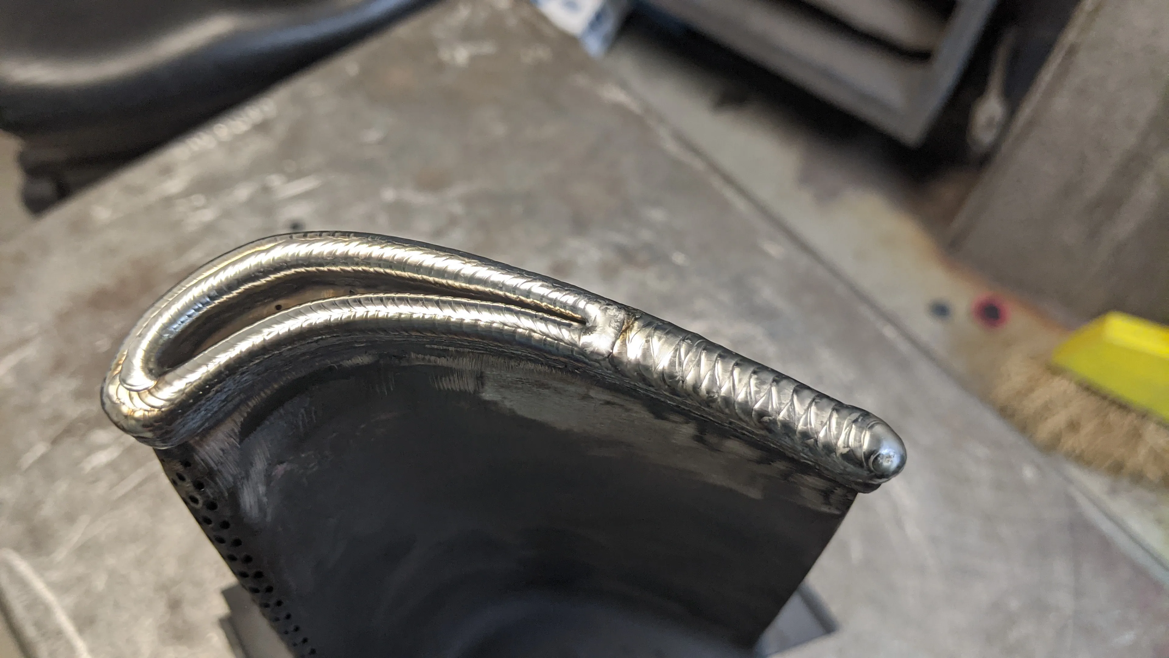 Close-up of a smooth weld along a curved steel edge